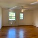Large family room with wood floors & good natural light. There is a door that leads to the outside storage closet and rear patio. We have added a ceiling fan which is AWESOME! All of our units have great updates including smooth ceilings!