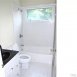 Tile hall bath has a transom window.